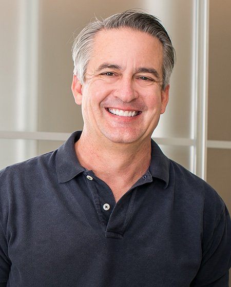 Smiling older man wearing a black polo shirt