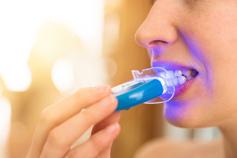 Patient brightening their teeth at home with teeth whitening